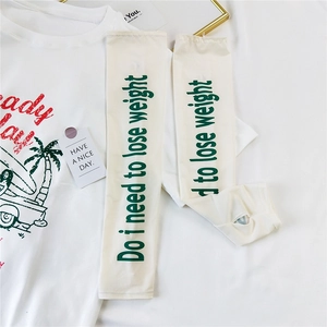 Detail of white sun protection arm sleeves with finger holes and green text print