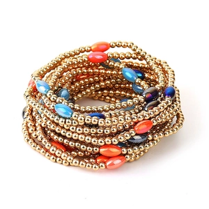 Detail of stacked handmade elastic bracelets with gold CCB beads and colorful oval accents