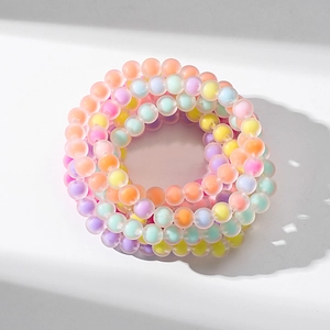 Close-up of stacked colorful frosted acrylic beaded bracelets in pastel macaron shades