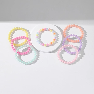Set of 7 colorful matte acrylic stretch bead bracelets on a white circular display