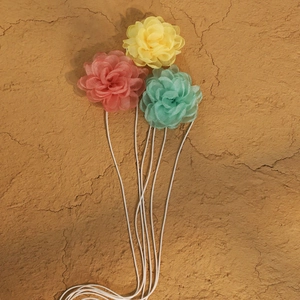 Detailed view of handmade multi-layer organza camellia flowers in soft pastel colors