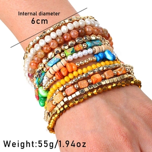Detail view of Bohemian layered stretch bracelets with various beads worn on a female wrist