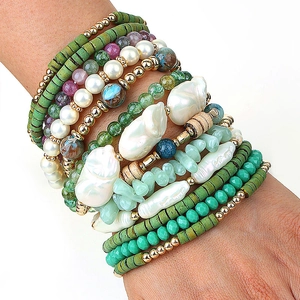 Détail de bracelets bohèmes en perles vertes et perles baroques sur poignet