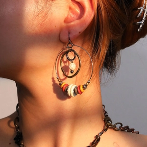 Bohemian style hoop earrings with vintage beads and brass rings worn by a model