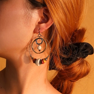 Close-up of bohemian multi-layer hoop earrings with colorful beads on a model