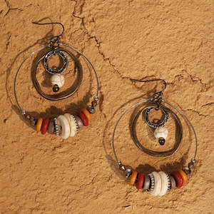 Detail of bohemian hoop earrings with white turquoise beads and hammered metal rings