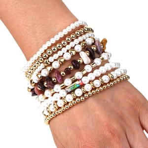Gros plan détaillé de bracelets multicouches avec pierres naturelles et breloque cœur