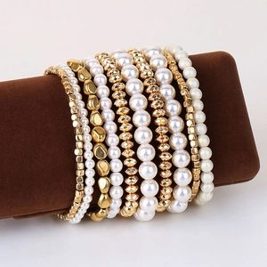 Elegant multi-layer white faux pearl and gold-plated beaded bracelet set on display