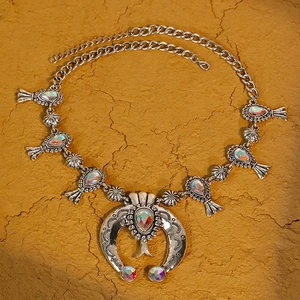 Collana bohémien in argento con corno, strass e pietre effetto opale su sfondo naturale