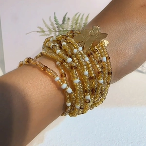 Handmade multilayer beaded bracelet featuring amber glass beads and gold butterfly charm