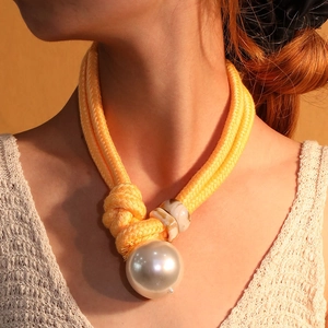 Minimalist yellow woven rope sweater chain necklace with a large white pearl pendant