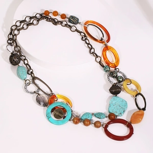 Bohemian long sweater necklace with vintage beads and resin rings on white tray