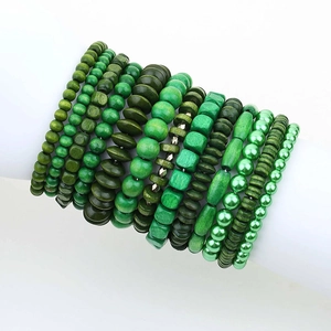 Stack of 13 bohemian green wooden and pearl bead bracelets on white display