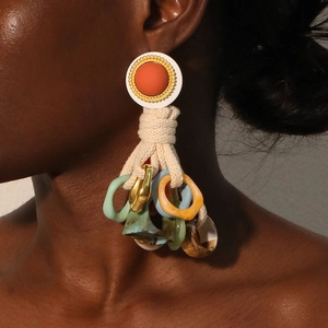 Boucles d'oreilles bohèmes avec anneaux en résine et corde tressée sur un mannequin