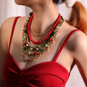 Détail macro du collier multicouche avec perles vertes et pendentifs cœur dorés