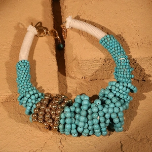 Detail of bohemian turquoise stone necklace with gold beads and cotton thread cord