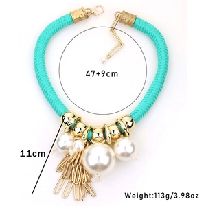 Dettaglio della collana bohémien in corda blu con grandi perle e nappe dorate