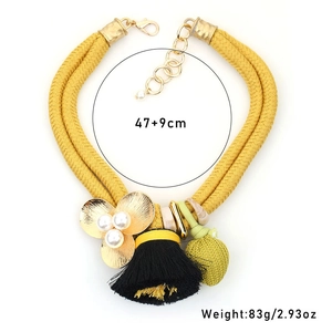 Détail du collier à pampilles double couche avec cordon jaune, fleur en perle et perle