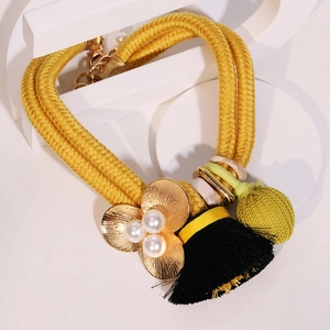 Collier plastron bohème avec cordes jaunes, fleur dorée et pompons décoratifs