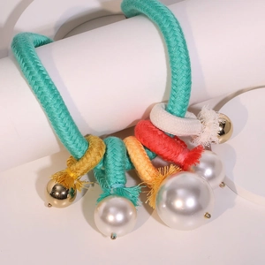 Collier tressé bohème multicolore avec perles d'imitation et glands sur support blanc