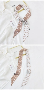 Close-up of narrow silk scarf with daisy floral pattern used as a neck tie on a shirt