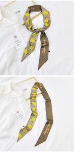 Detail of taupe silk twilly scarf with yellow pear print and gold positive embroidery