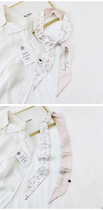Detail of floral twilly silk scarf with Positive Thinking text tied on a white shirt