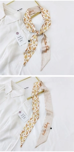 Detail of a beige silk twilly scarf with pear fruit prints and Positive Thinking quote