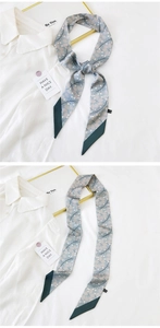 Detail view of a floral skinny scarf in grayish blue, tied elegantly on a white shirt