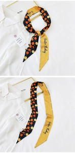 Detailed view of a double-sided twilly scarf featuring citrus prints and Positive Thinking text