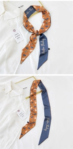 Detailed view of reversible twilly silk scarf featuring orange pear print and navy embroidery