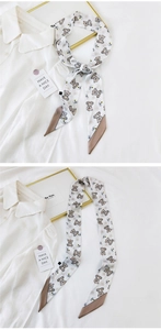 Detail of skinny silk scarf with bear print and brown diagonal tips on a white shirt