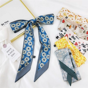 Elegant printed narrow silk scarf tied in a bow with assorted floral patterns