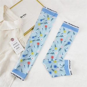 Détail de manchettes de protection solaire bleu clair en soie glacée à motif marguerites