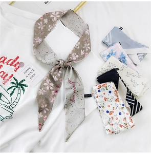 Detail eines schmalen Satinschals mit 'love yourself'-Print auf weißem Hemd