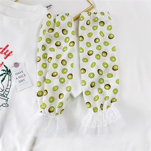Detail of white lace cuffs with kiwi fruit print on lightweight sun protection sleeves