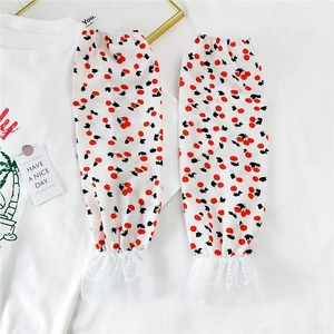 Detail of white summer sun sleeves with red cherry print and delicate lace cuffs