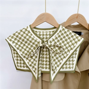 Detail of green houndstooth decorative shawl collar with ribbon tie on trench coat