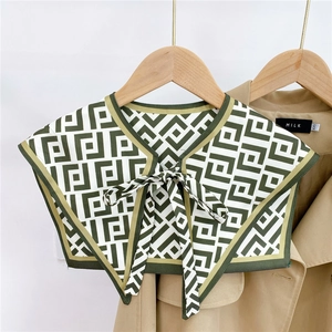 Detail of green geometric pattern faux collar shawl with tie bow on a khaki coat