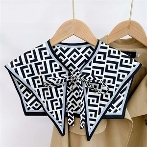 Detail of black and white geometric pattern decorative shawl collar with ribbon tie