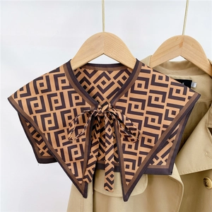 Detail of vintage geometric pattern silk scarf collar with long tie on a trench coat