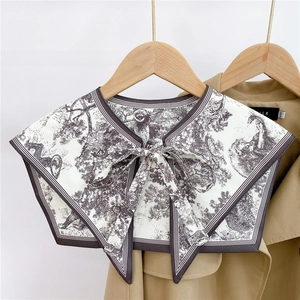 Detail of detachable beige scarf collar with gray toile de jouy print on trench coat