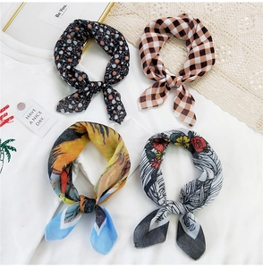 Close-up of four floral cotton-linen scarves in various patterns with elegant bow designs