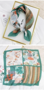 Detail of square cotton linen scarf with dark green botanical leaf and geometric patterns