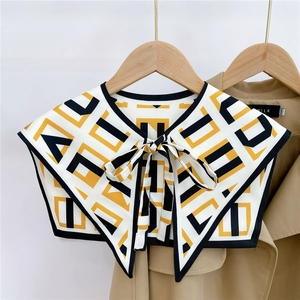 Detail of geometric pattern shawl collar with a decorative bow on a khaki trench coat