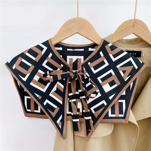 Detail of geometric pattern shawl collar with bow tie on a beige trench coat background