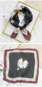 Detailed view of gray cotton linen scarf with white daisy print and striped border