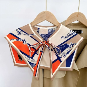 Detail of silk scarf shawl with abstract geometric print and tie closure on a hanger