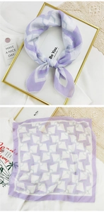Detail of square cotton linen scarf with purple geometric pattern and soft texture