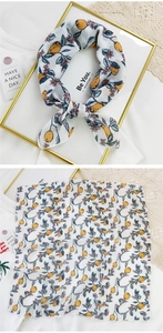 Detailed view of square cotton linen scarf with vibrant lemon and floral print patterns